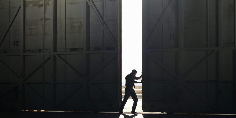 man pushing door open